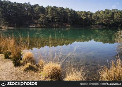Beautiful landscape image of old clay pit quarry lake with unusual colored green water