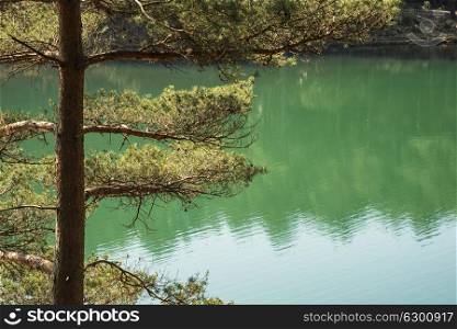 Beautiful landscape image of old clay pit quarry lake with unusual colored green water