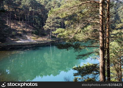 Beautiful landscape image of old clay pit quarry lake with unusual colored green water