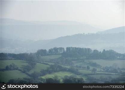 Beautiful landscape image of the Peak District in England on a hazy Winter day viewed from the lower slopes of Bamford Edge