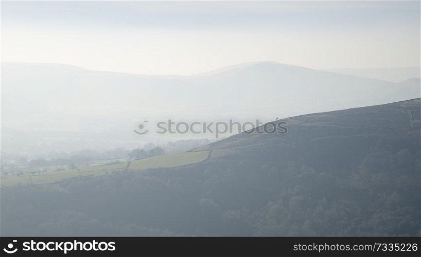 Beautiful landscape image of the Peak District in England on a hazy Winter day viewed from the lower slopes of Bamford Edge