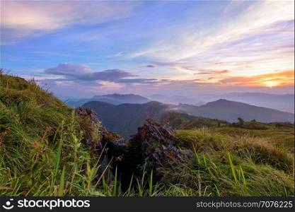 Beautiful landscape nature on peak mountain with sun cloud fog and bright colors of sky and sunlight during sunset in winter at viewpoint Phu Chi Fa Forest Park in Chiang Rai Province, Thailand