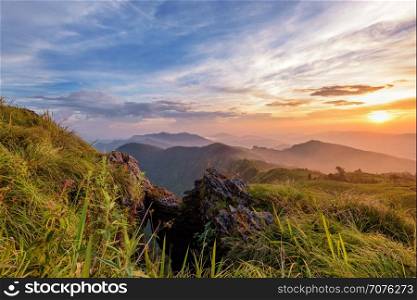 Beautiful landscape nature on peak mountain with sun cloud fog and bright colors of sky and sunlight during sunset in winter at viewpoint Phu Chi Fa Forest Park in Chiang Rai Province, Thailand