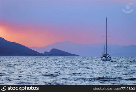 Beautiful Landscape of Amazing Purple-Orange Sunset over Mediterranean Sea. Traveling on Sailboat along Turkey. Summer Vacation. Beauty of Nature.. Sailboat over Sunset Sky