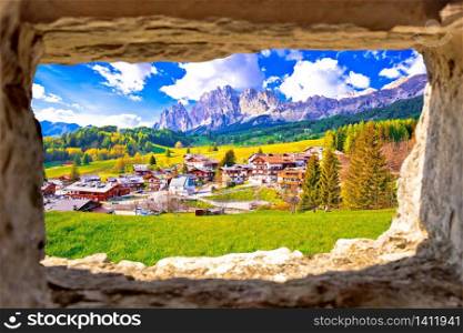 Beautiful landscape of Cortina d&rsquo; Ampezzo in Dolomites Alps view through stone window, Veneto region of Italy