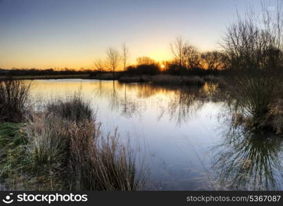 Beautiful landscape of English countryside during Winter sunrise with vibrant colors