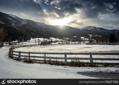 Beautiful landscape of farm with wooden fence at highland Austrian town at sunset