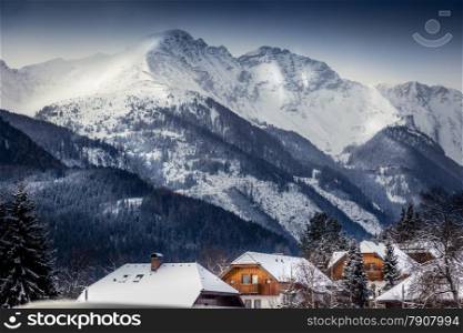 Beautiful landscape of high Austrian Alps with traditional houses covered by snow