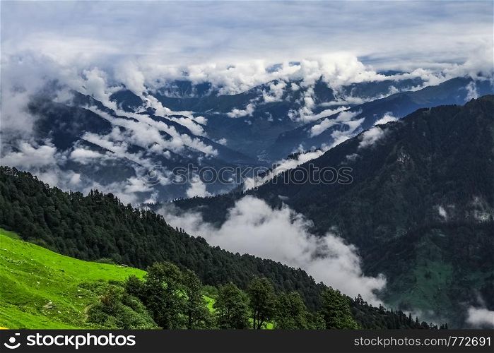Beautiful landscape of Manali City surrounded by clouds as seen from the Chanderkhani pass at 12000 ft. The camera faces north. Behind, Solang Valley and Rohtang Pass can be seen