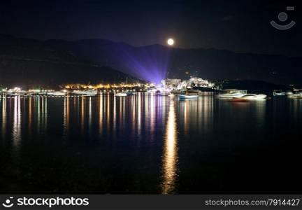 Beautiful landscape of moon shining over seaside city at dark night