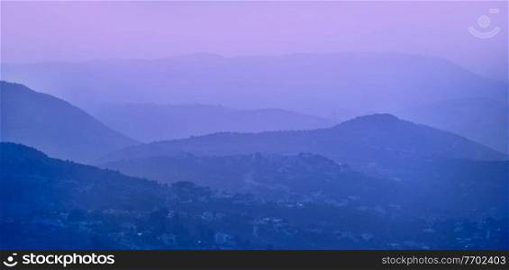 Beautiful landscape of mountains, little town in the fog, purple pastel sunrise, natural background, Lebanon
