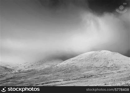 Beautiful landscape of snow covered mountain range in Winter in black and white