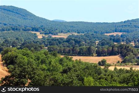 Beautiful landscape of summer countryside with hills, wheat field, cupress and forest
