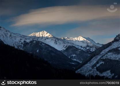 Beautiful landscape of sun shining on mountain top covered by snow