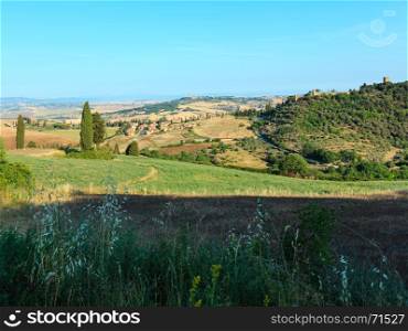 Beautiful landscape of Tuscany summer morning countryside in Montepulciano region. Typical for the Italy region Toscana hills, wheat field, olives garden, vineyards, cypress passes.