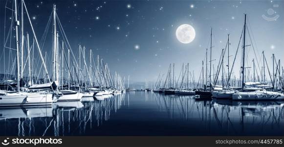 Beautiful landscape of yacht harbor at night, full moon, marina in bright moonlight, luxury water transport in nighttime, vacation concept