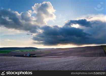 Beautiful landscape over agricultural fields with moody sky and invigorating sunlight