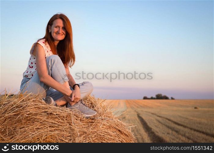 beautiful landscape - round bales and a girl in the field