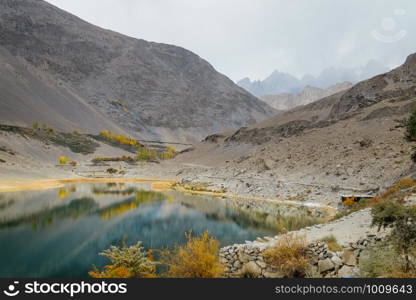 Beautiful landscape scenery of reflection in water of Borith lake against Karakoram mountain range. Autumn season in Gulmit Gojal, Hunza Valley. Gilgit Baltistan, Pakistan.