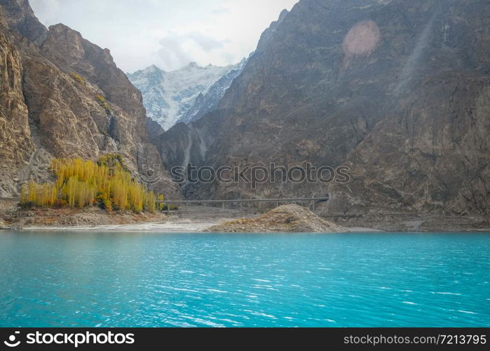 Beautiful landscape scenery of turquoise blue water of Attabad lake in autumn season against snow capped mountain in Karakoram range. Gojal, Hunza Valley. Gilgit Baltistan, Pakistan.