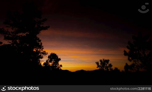 Beautiful landscape silhouette on the mountain peak during sunset with warm sunlight and dramatic sky.