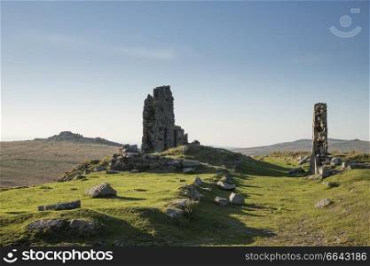 Beautiful landscape sunset image over abandoned Foggintor Quarry in Dartmoor with raking soft sunlight over ruins and derelict buildings