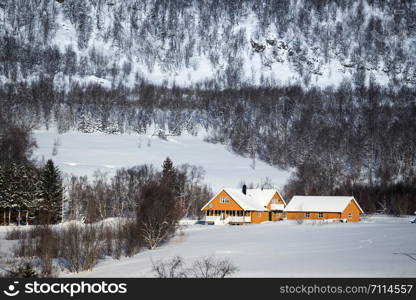 beautiful landscape. traditional norwegian wooden yellow house and mountains in the distance. Lofoten Islands. Norway.