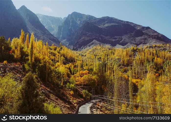 Beautiful landscape view of Gupis valley. Colorful trees in autumn season against Hindu Kush mountain range. Gilgit Baltistan, Pakistan.