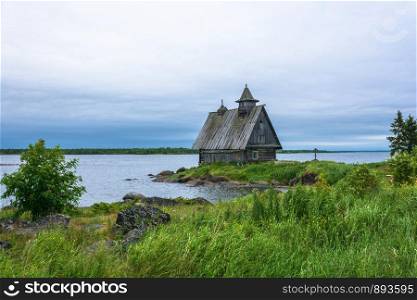 Beautiful landscape with a wooden chapel on the shore of Onega bay of Karelia, Russia.