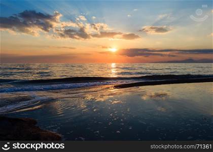 Beautiful landscape with tropical sea sunset on the beach. Picturesque sky reflection in water.