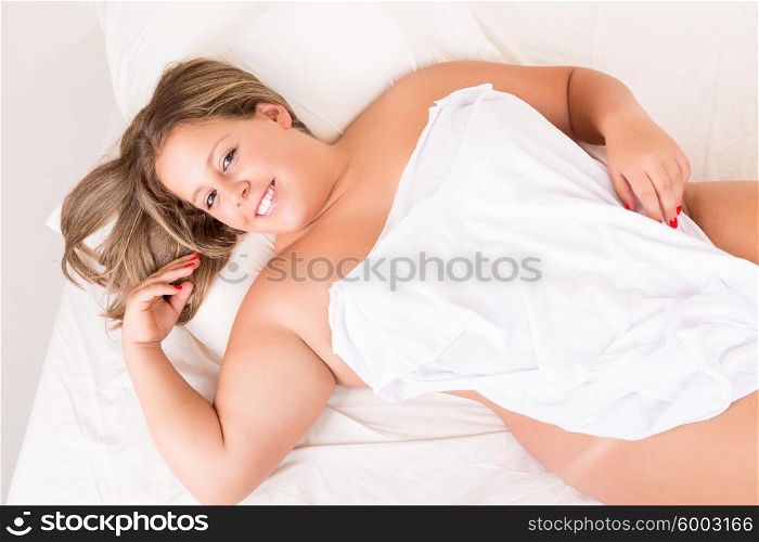 Beautiful large woman relaxing on her bed