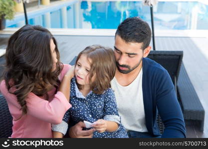 Beautiful latin family relaxing close to the pool