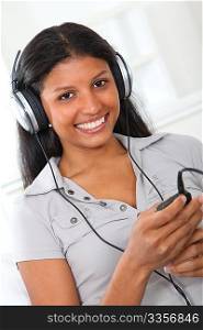 Beautiful latin girl listening to music with headphones