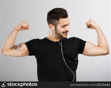 Beautiful latin man listen music and appreciate his own muscles