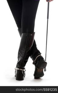 beautiful legs in black leather horseman boots with riding-crop over white