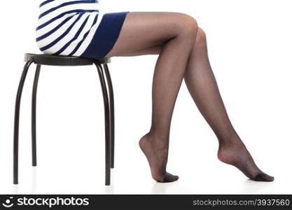 Beautiful legs of slim girl. Beauty woman legs in black tights. Part body of slim attractive girl wearing striped dress skirt and pantyhose isolated on white.