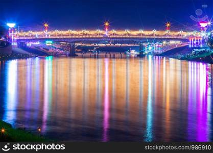 Beautiful light on the Nan River at night on the bridge (Naresuan Bridge) in day The Loy Krathong festival in Phitsanulok City, Thailand.