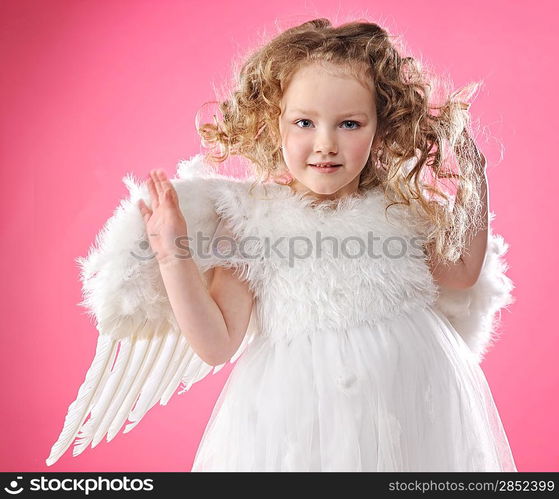 Beautiful little angel girl isolated on pink background