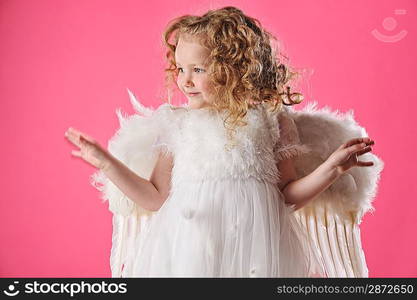 Beautiful little angel girl isolated on pink background