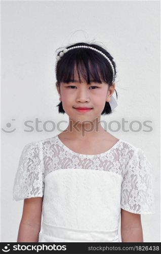 Beautiful little Asian girl in dress over white background.