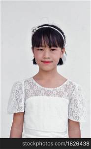 Beautiful little Asian girl in dress over white background.