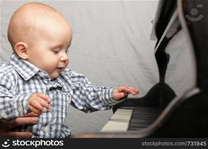 beautiful little baby boy learning plays piano