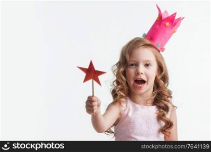 Beautiful little candy princess girl in crown holding star shaped magic wand isolated on white. Princess girl holding magic wand