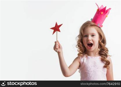 Beautiful little candy princess girl in crown holding star shaped magic wand isolated on white. Princess girl holding magic wand