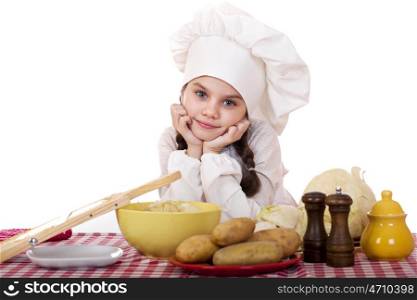 Beautiful little chief cooker on the desk with vegetables, isolated on white background