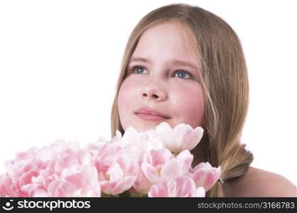 Beautiful little girl giving a bouquet of pink tulips