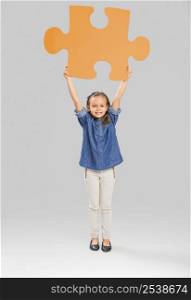 Beautiful little girl holding a big blue Puzzle