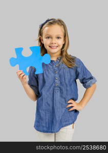 Beautiful little girl holding a blue Puzzle