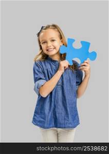 Beautiful little girl holding a blue Puzzle