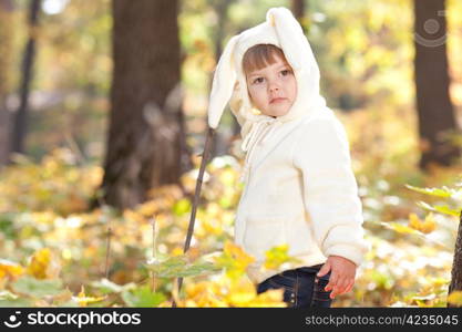 beautiful little girl in costume bunny in the autumn forest